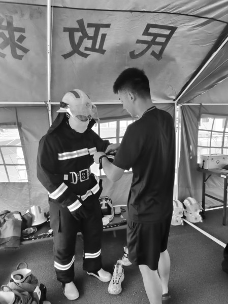 为了重现火场的真实情况,消防员们顶着烈日,穿上厚厚的“战斗服”